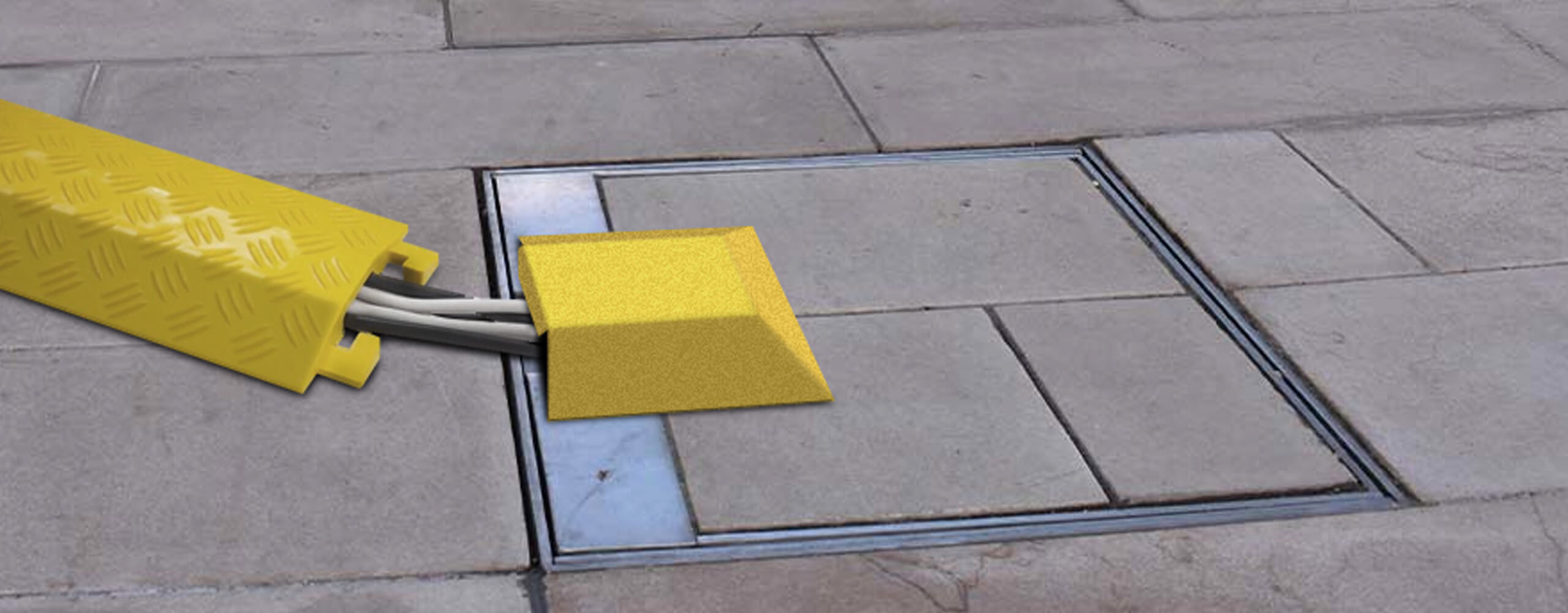 Image of an in-ground unit with hinged lid closed and locked with power cables covered by a cable protector