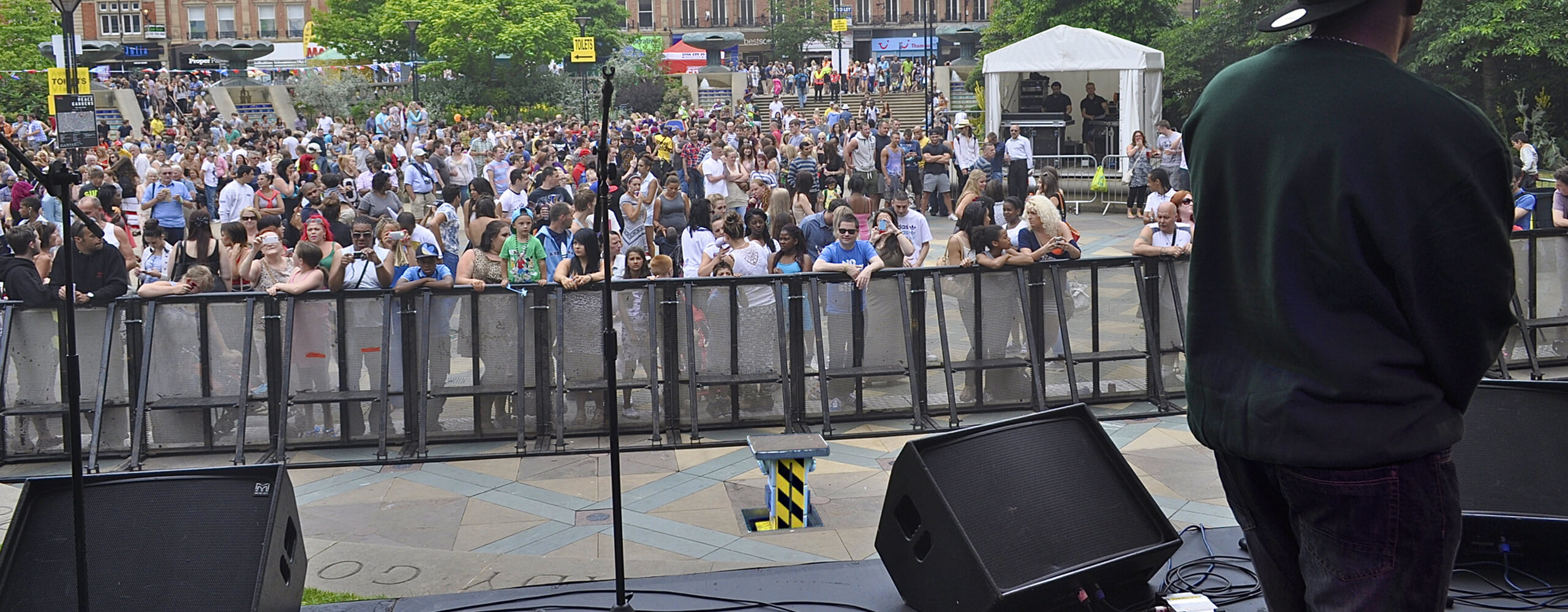 Image showing a view from a stage looking out across crowds with a pop up power unit in front of crowd barriers